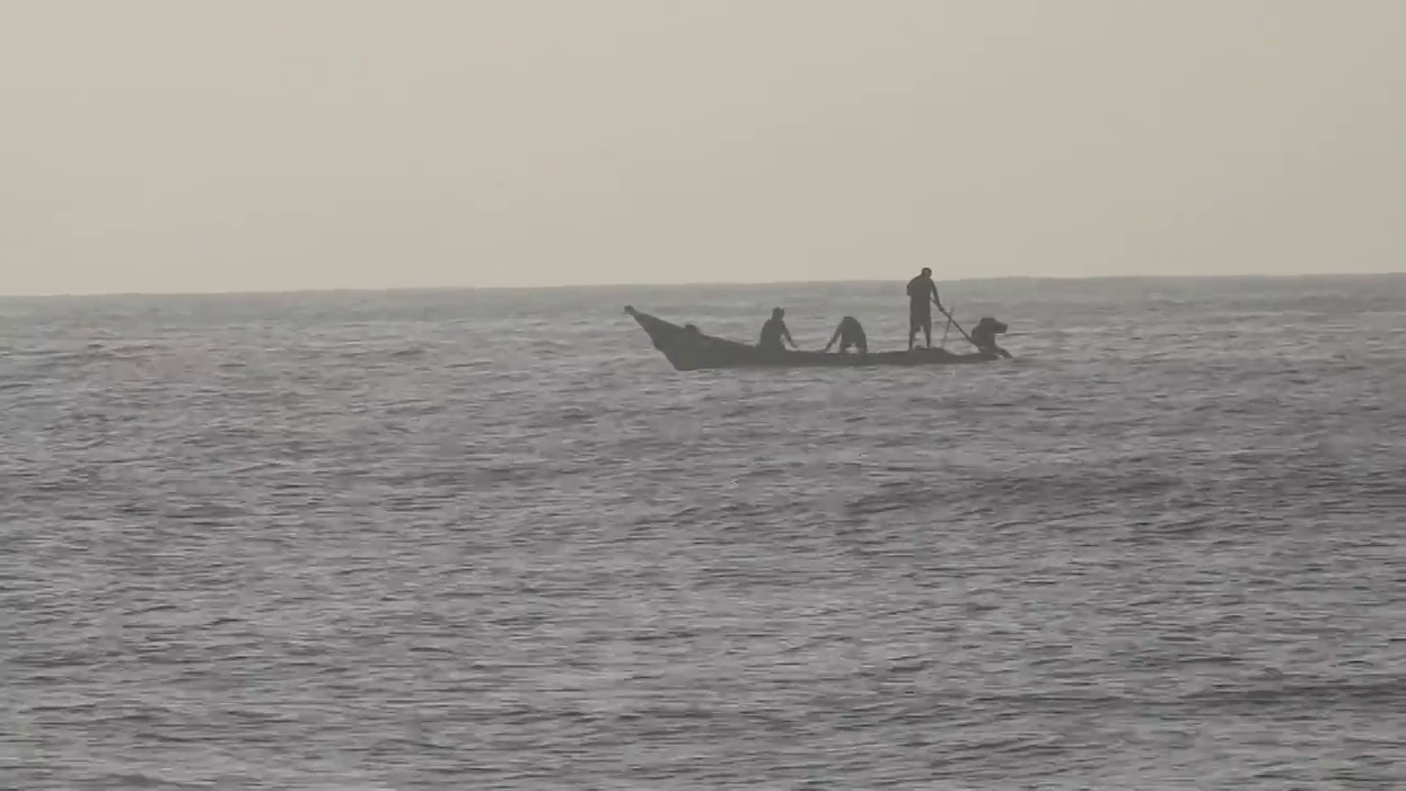 早上，人们在海洋中乘木筏钓鱼。海浪翻滚翻滚，波浪起伏，美丽的沙滩细密而清澈的海水和岸边的天空。视频素材