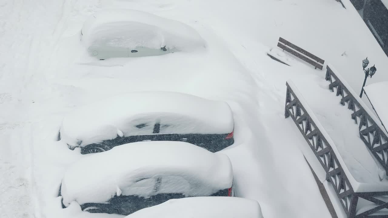 停车场里积着雪。汽车被雪覆盖了。的雪堆。大雪视频素材