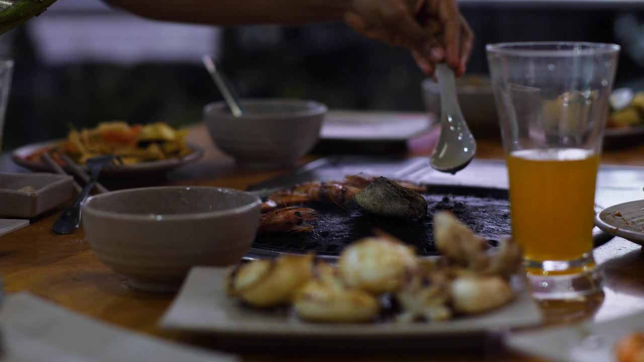 近距离观看一张桌子与烧烤炉满食物在自助餐餐厅。视频素材