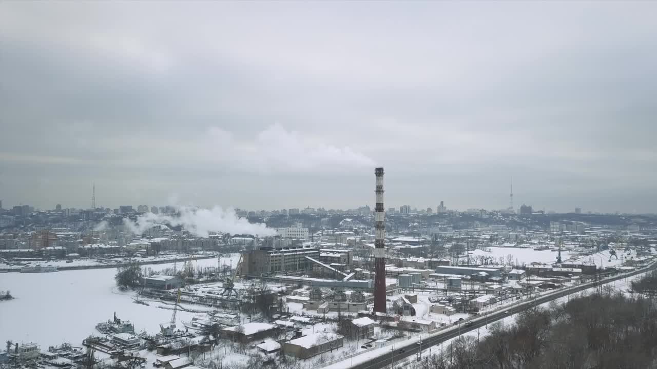 飞越工业区，到达热动力网络的管道，装载码头上有冰冻的水。城市的背景是缕缕的烟雾视频素材