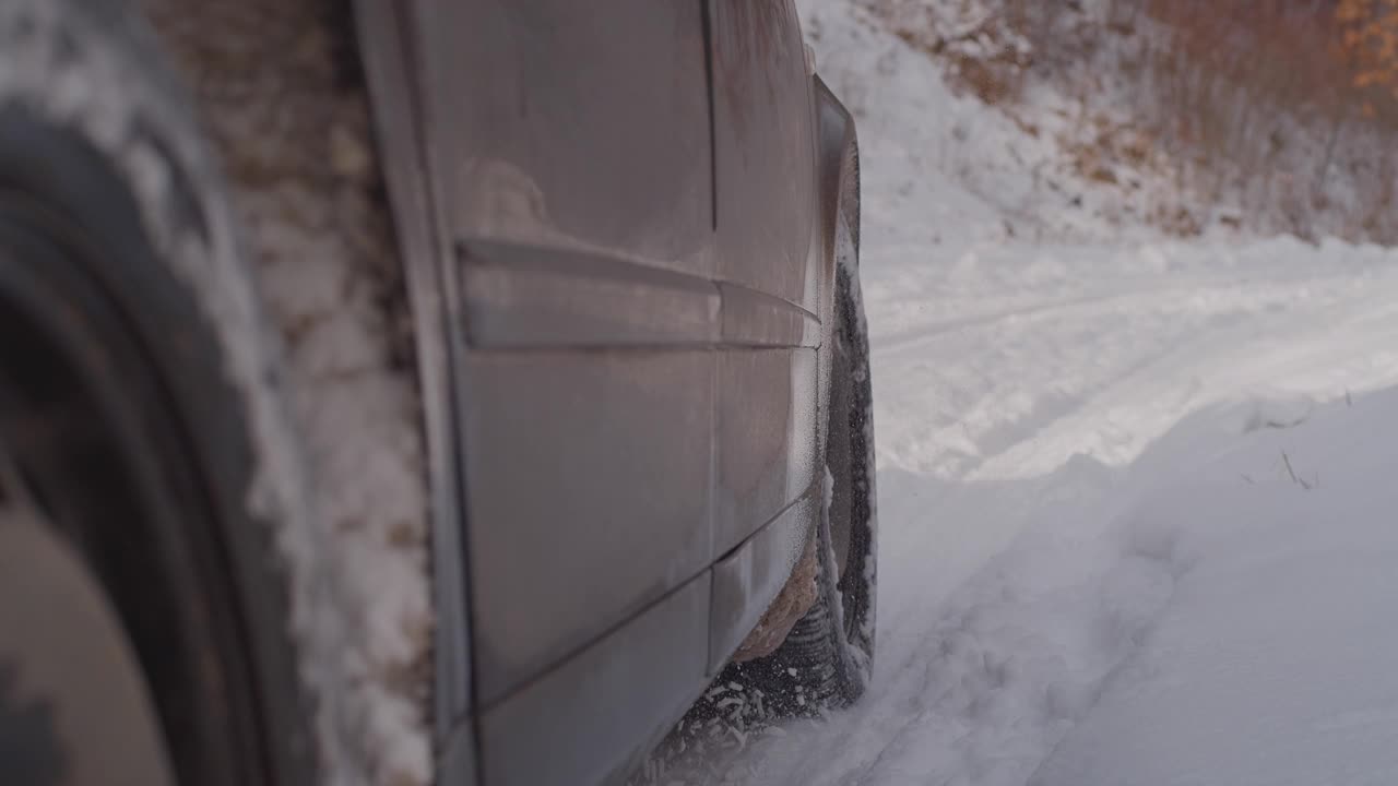 汽车在雪地上行驶的轮胎靠近了视频素材