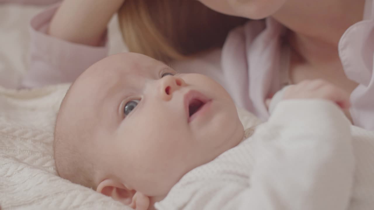 妈妈亲吻和抚摸床上的女儿视频素材