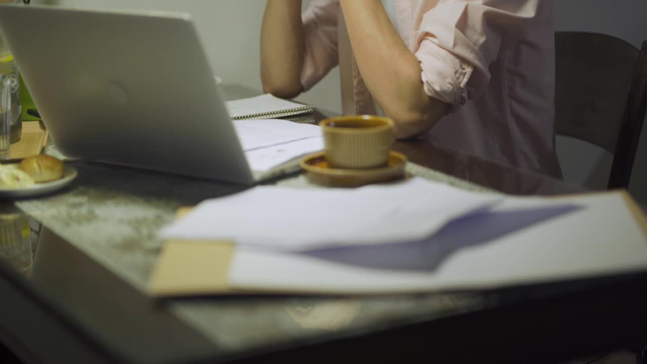 晚上加班亚洲华人男性在家里餐厅工作到很晚，情绪压力和他的财务账单在晚上单独视频素材