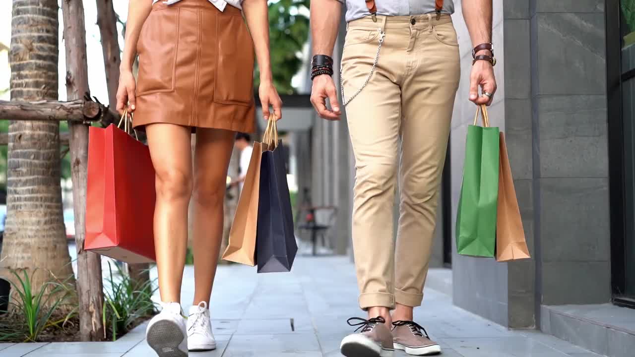 潮人，拿着购物袋走在人行道上的男男女女视频素材