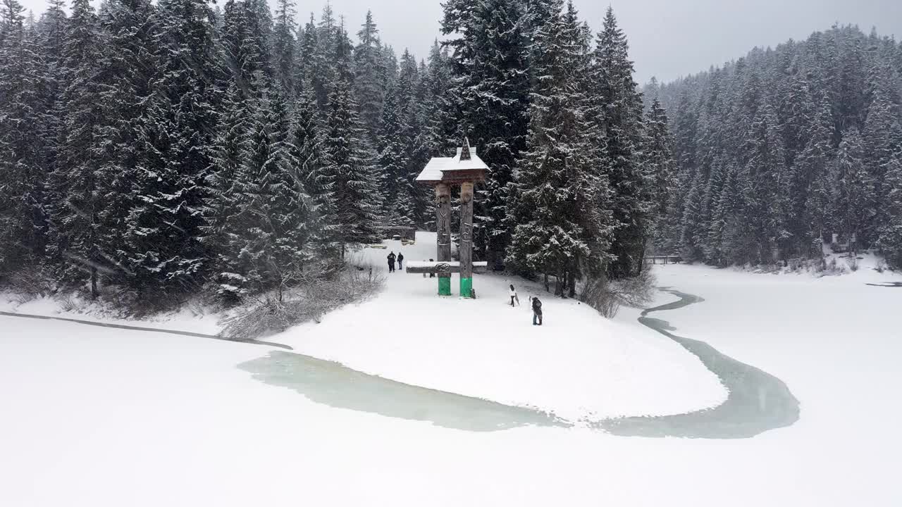 鸟瞰图冰冻森林与冰雪覆盖的湖在冬季在喀尔巴阡山脉视频素材