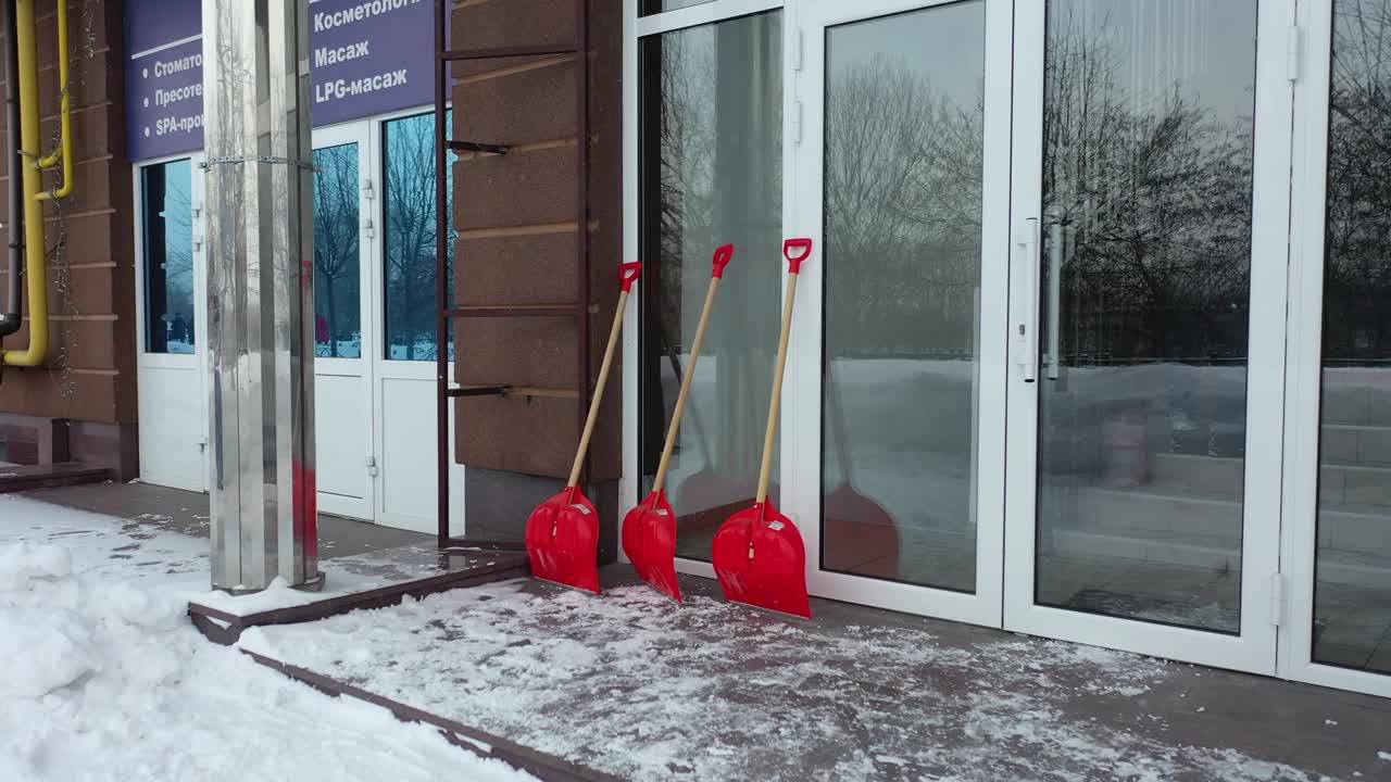 在入口处用铁铲清除积雪。视频素材