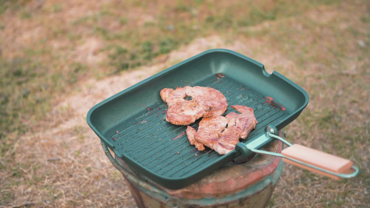 近距离拍摄一对旅行情侣在露营做饭，旅游目的地，自然旅游的概念。视频素材