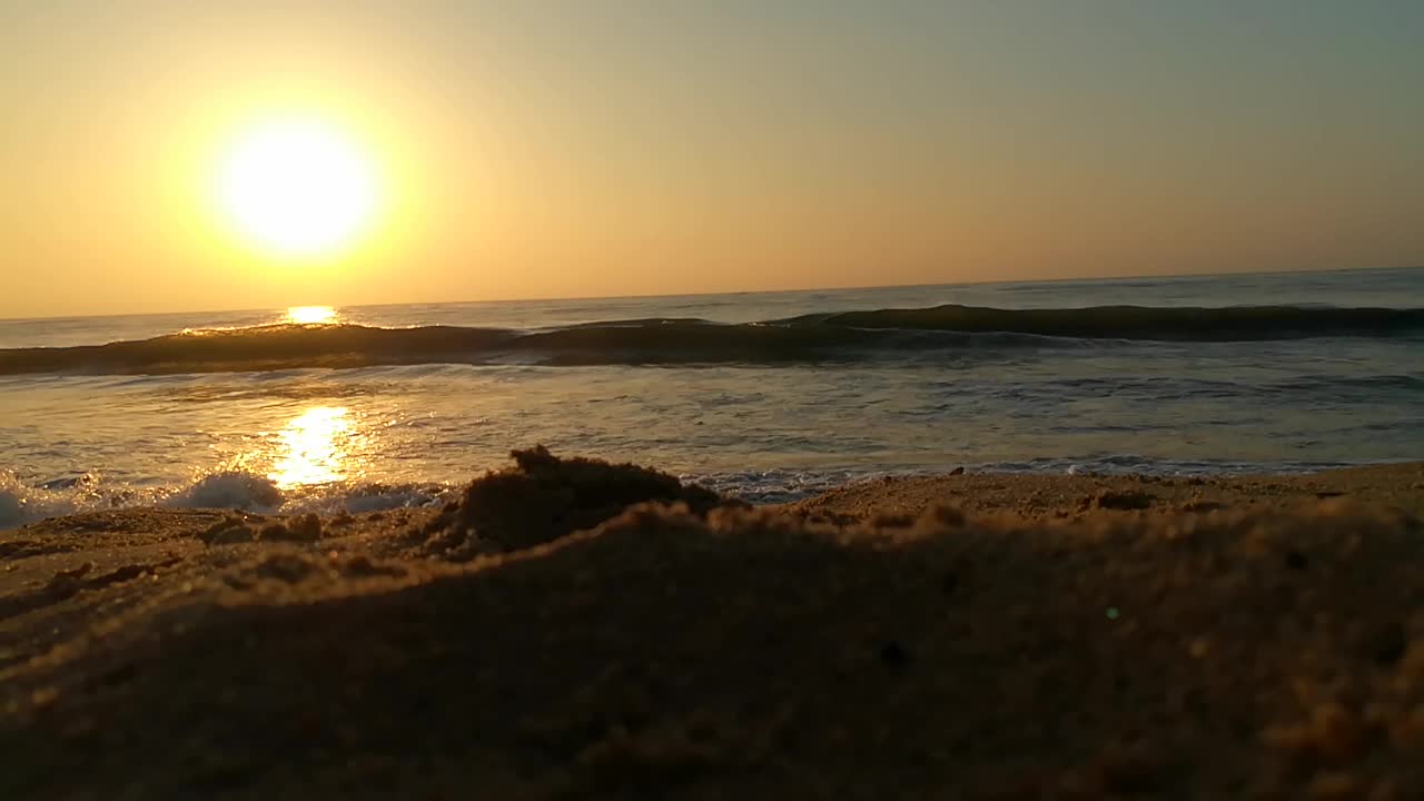 海面上的小波浪日落。金色的夕阳和黄色的阳光。海面上的日出景观。海滩上金色的日出。橙色的日出。视频素材