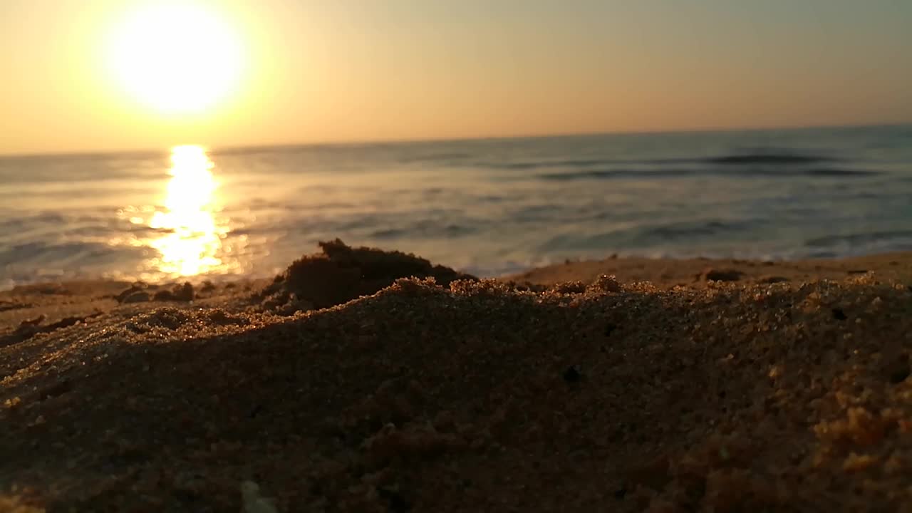 海面上的小波浪日落。金色的夕阳和黄色的阳光。海面上的日出景观。海滩上金色的日出。橙色的日出。视频素材