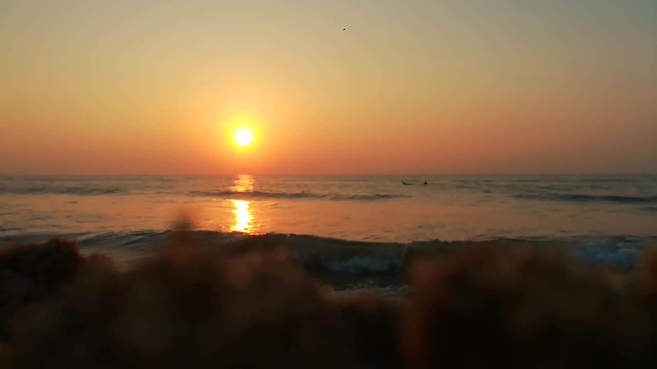 《海边的日落》美丽的日落在海上。夕阳和海浪。海面上的日出景观。海滩上金色的日出。海洋的日出。红色，大海，日出-黎明，太阳，海滩，大海，自然，日落，橙色，风景-风景，水，沙子，浪-水，视频素材