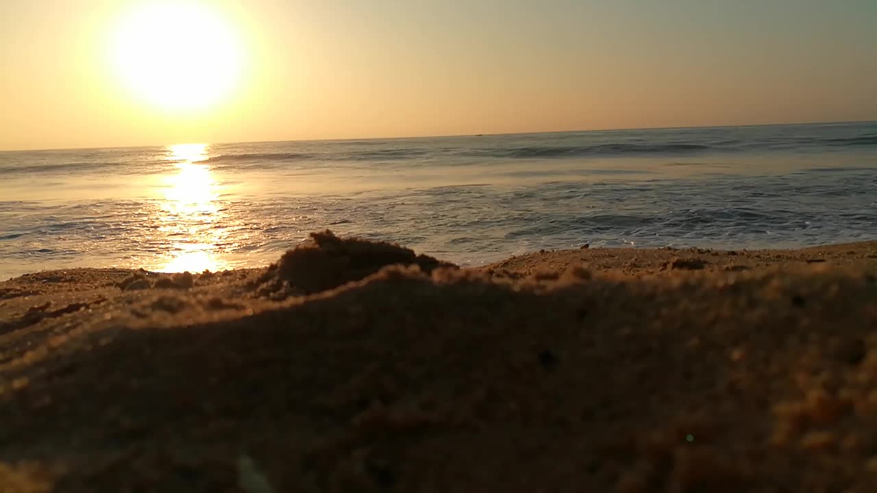 海面上的小波浪日落。金色的夕阳和黄色的阳光。海面上的日出景观。海滩上金色的日出。橙色的日出。视频素材