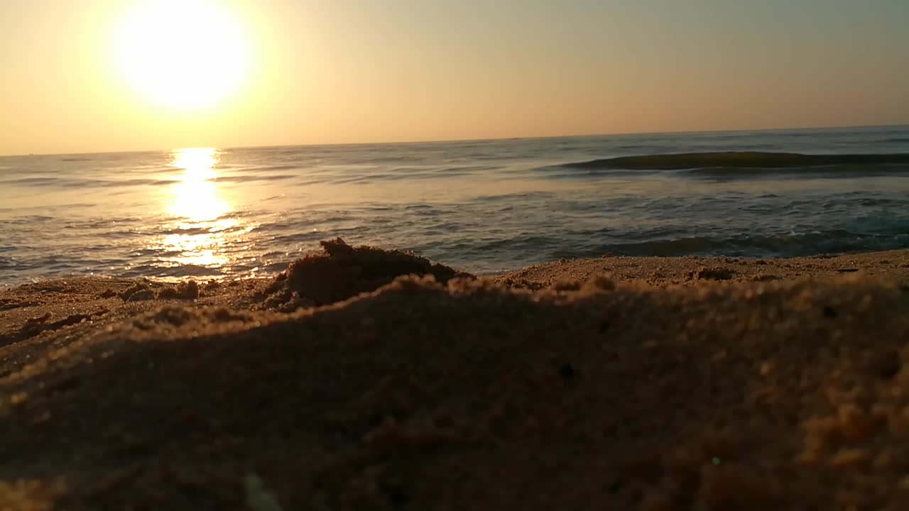 海面上的小波浪日落。金色的夕阳和黄色的阳光。海面上的日出景观。海滩上金色的日出。橙色的日出。视频素材