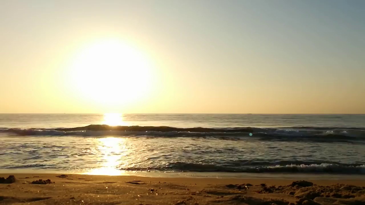 海面上的小波浪日落。金色的夕阳和黄色的阳光。海面上的日出景观。海滩上金色的日出。橙色的日出。视频素材