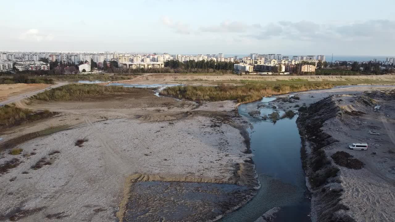 从右到左，无人机可以看到摇摇晃晃的小溪和城市景观。视频素材