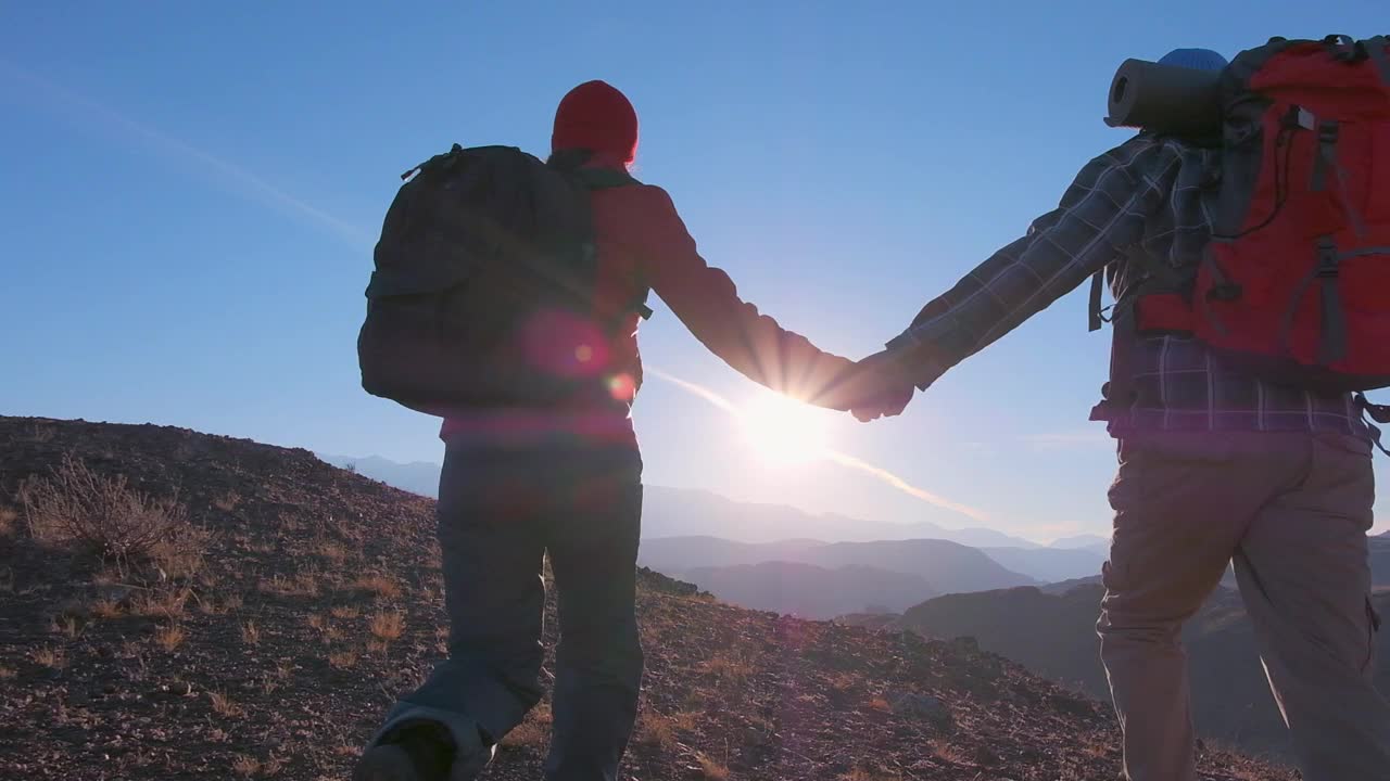 幸福的夫妇旅行者男人女人背包爬上跑步庆祝成功在山顶日落视频素材