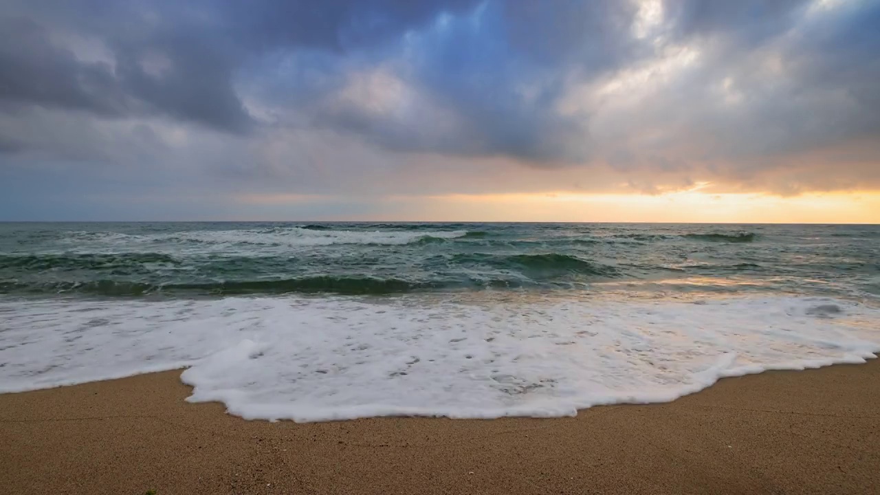 海边的日出和浪花溅在沙滩上视频素材