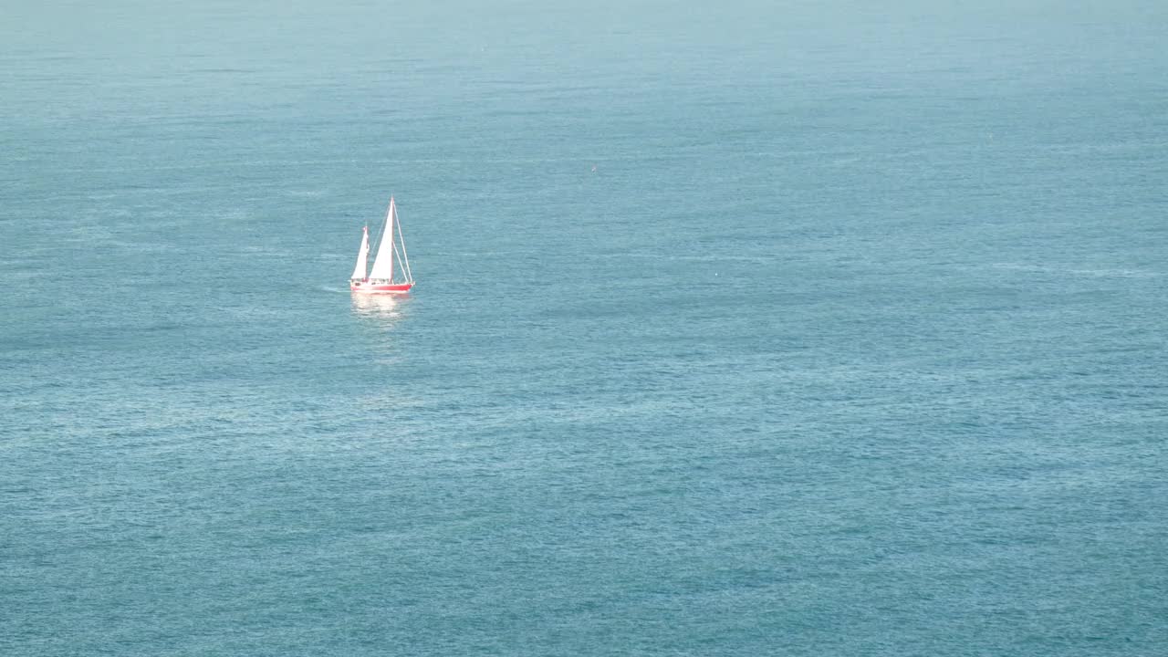 在葡萄牙纳扎尔北部海滩(Praia do Norte)泛起涟漪的海水上巡航的船只视频素材