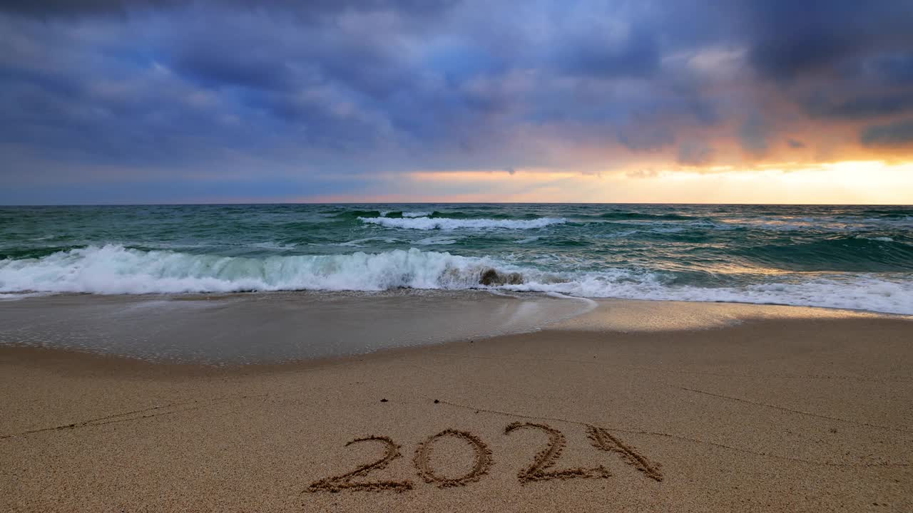 海滩日出，沙滩上写着2021年的新年视频素材