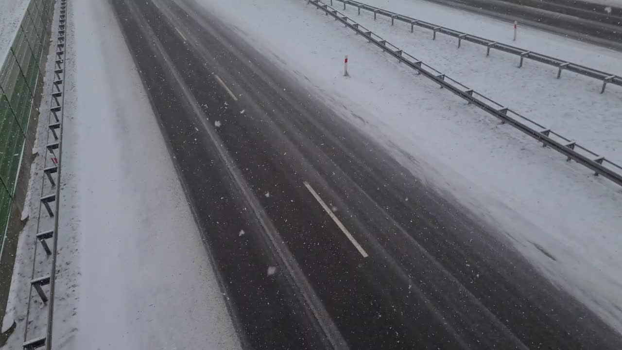 从桥上俯瞰，在暴风雪中高速公路上行驶的汽车视频素材