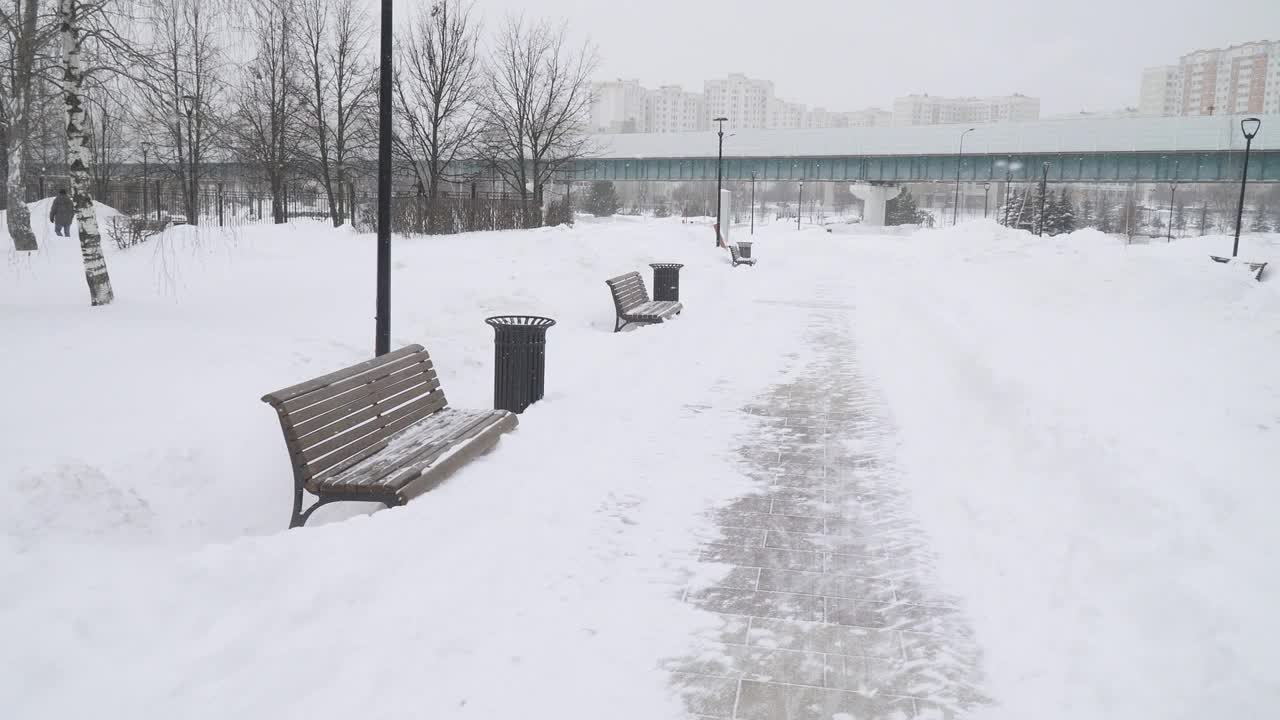 一场大雪过后，在莫斯科城市住宅区清理公园的小路视频素材