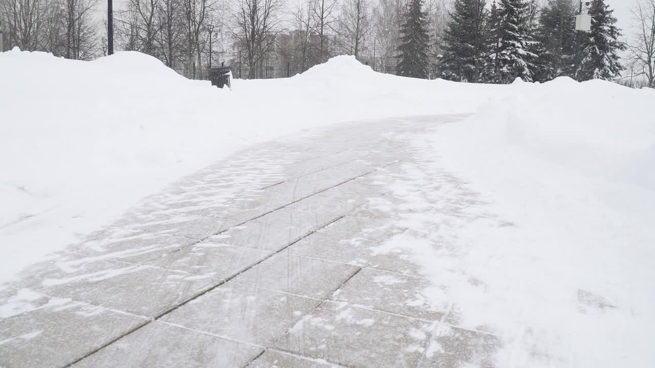 一场大雪过后，在莫斯科城市住宅区清理公园的小路视频素材