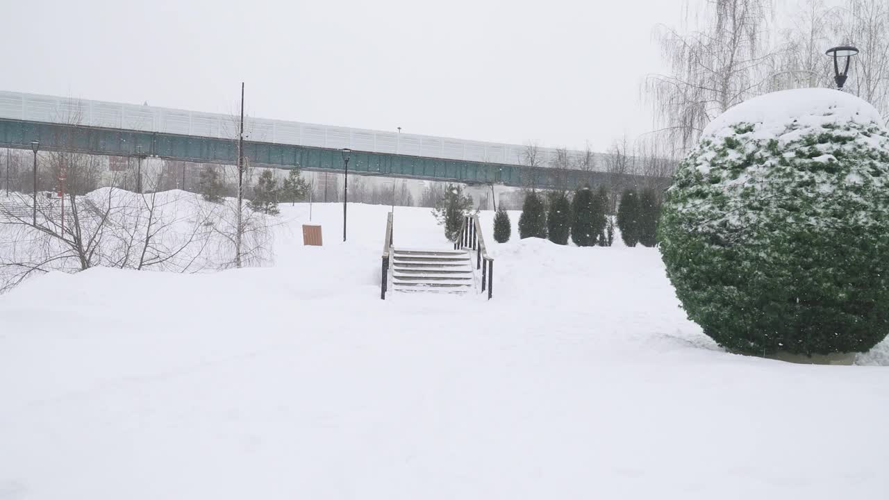 一场大雪后，莫斯科城市Yuzhnoe Butovo住宅区的一座公园里的木桥视频素材