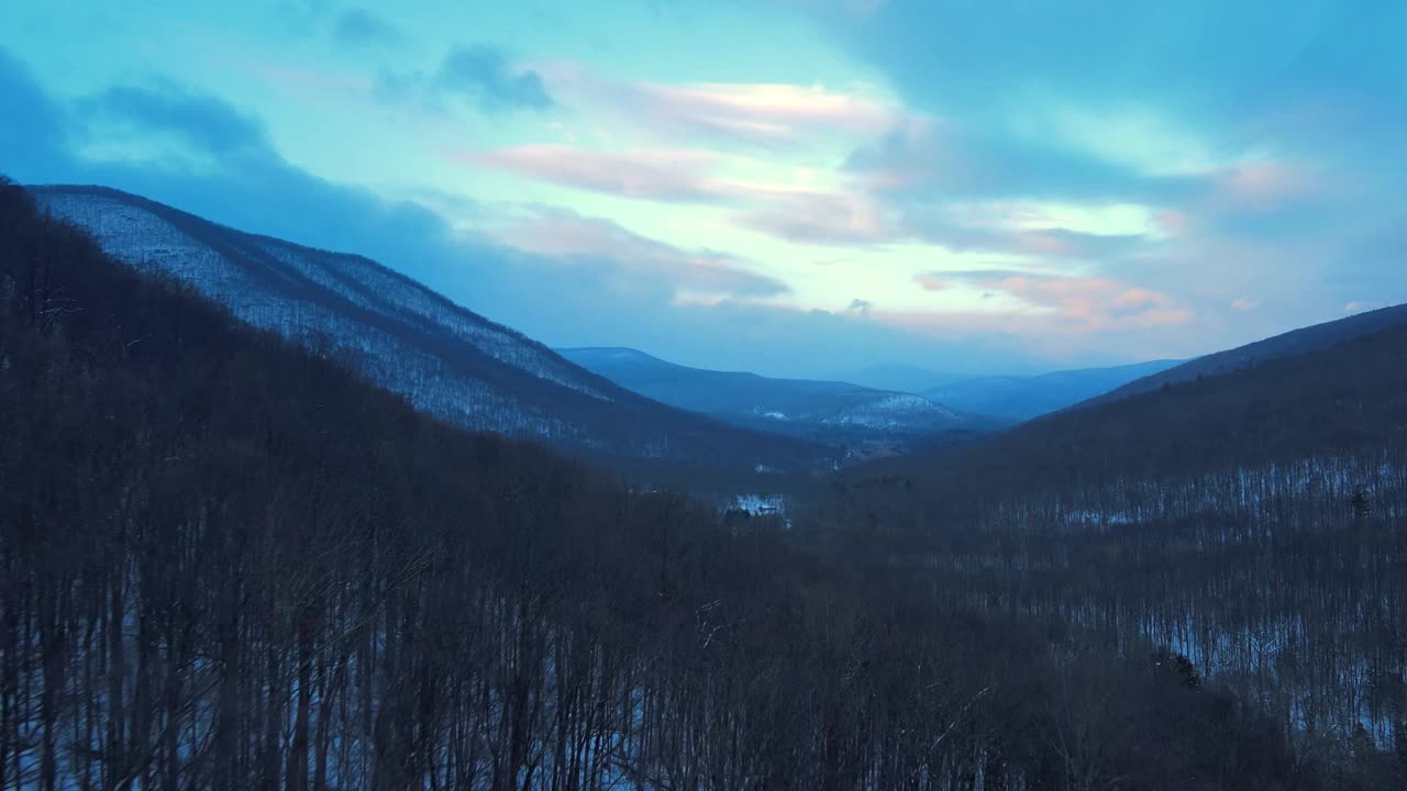 无人机拍摄的黄昏时分白雪覆盖的山谷视频素材