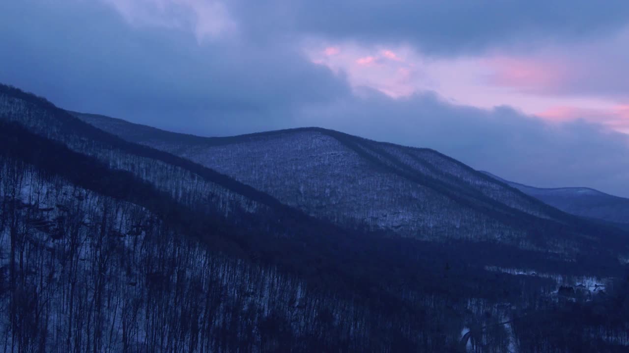 无人机拍摄的黄昏时分白雪覆盖的山谷视频素材