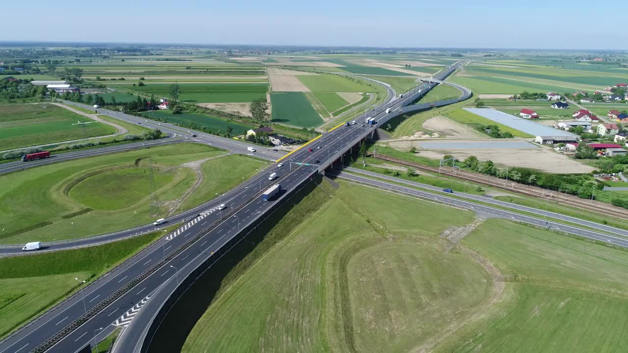 高速公路高架桥横跨当地公路和铁路线。一架无人机在一个阳光明媚的日子里拍摄视频素材