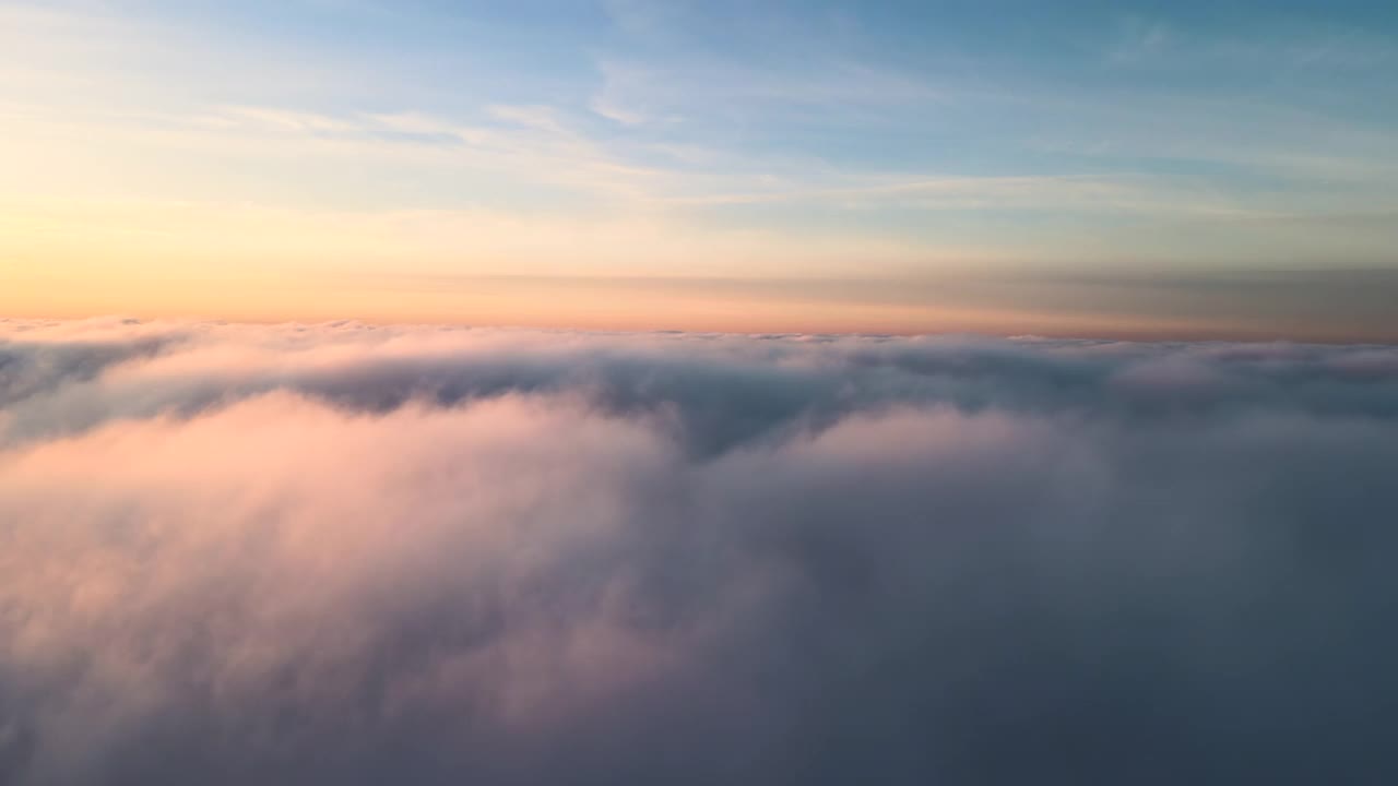 鸟瞰图充满活力的黄色日出在白色密集的云与蓝色的天空头顶。视频素材