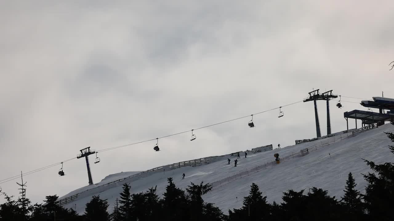 雪山滑雪坡道上的滑雪缆车和滑雪者视频素材