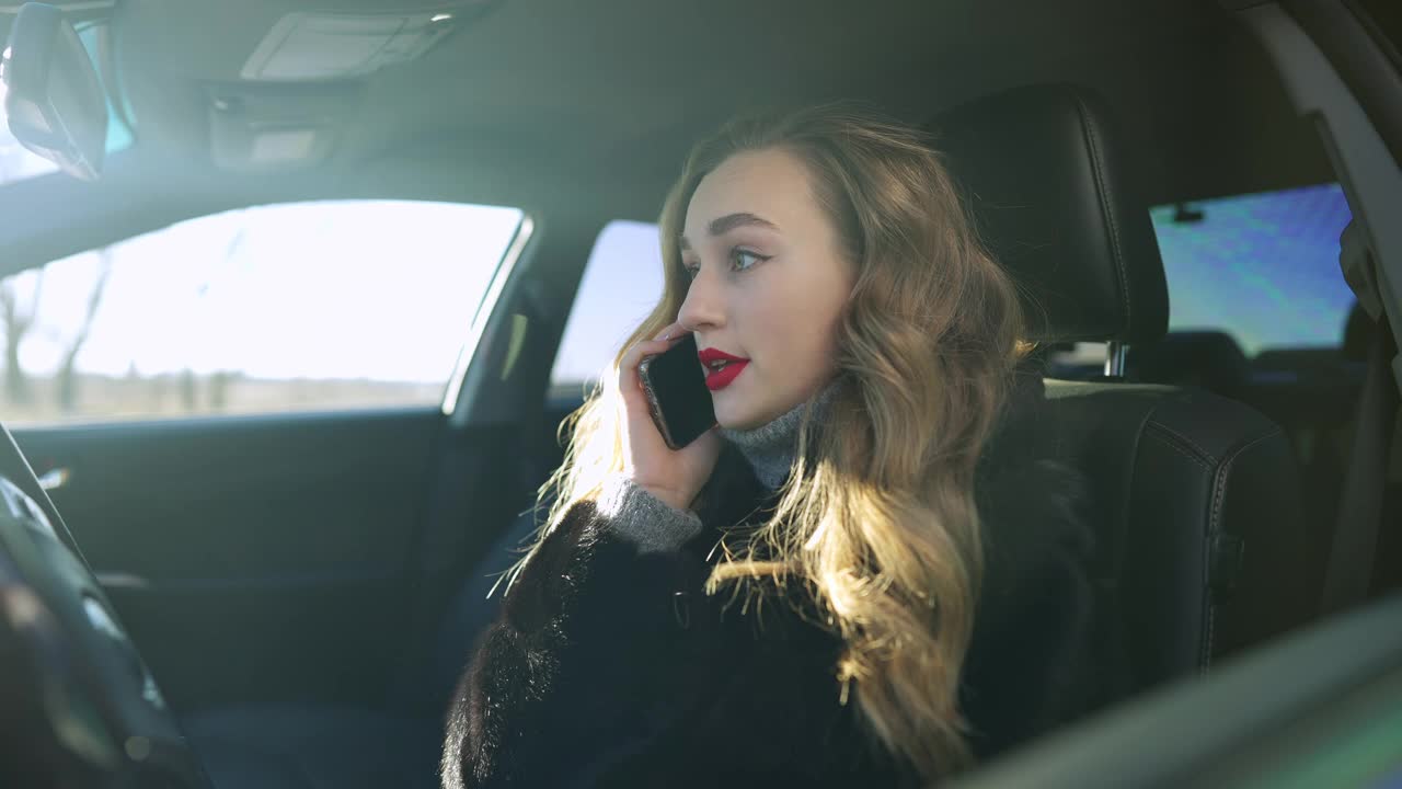 年轻的白人褐发女人坐在车里的驾驶座上一边打电话一边吵架。侧视图肖像强调自信的富夫人在汽车中大喊的慢动作。压力和问题视频素材