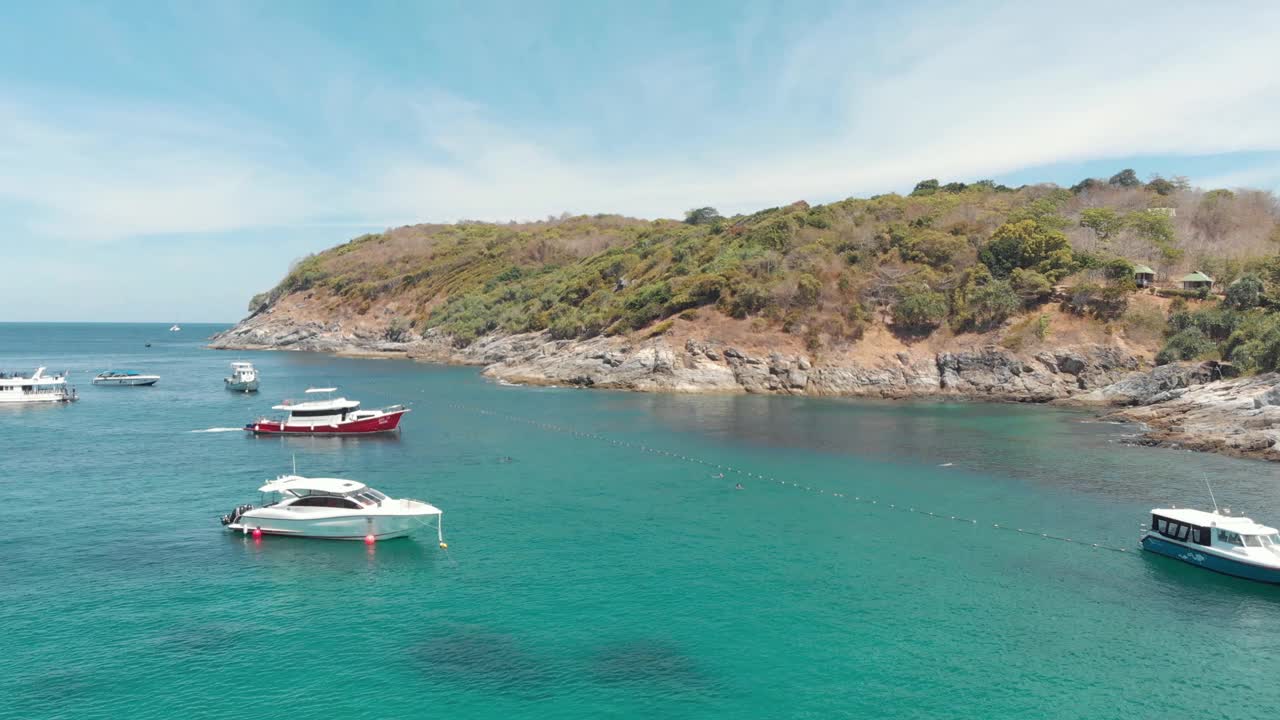 停泊的渔船和旅游游艇在天堂般的浅水上休息，在泰国普吉岛海岸外的Ko Racha Yai岛-空中低缓慢全景拍摄视频素材