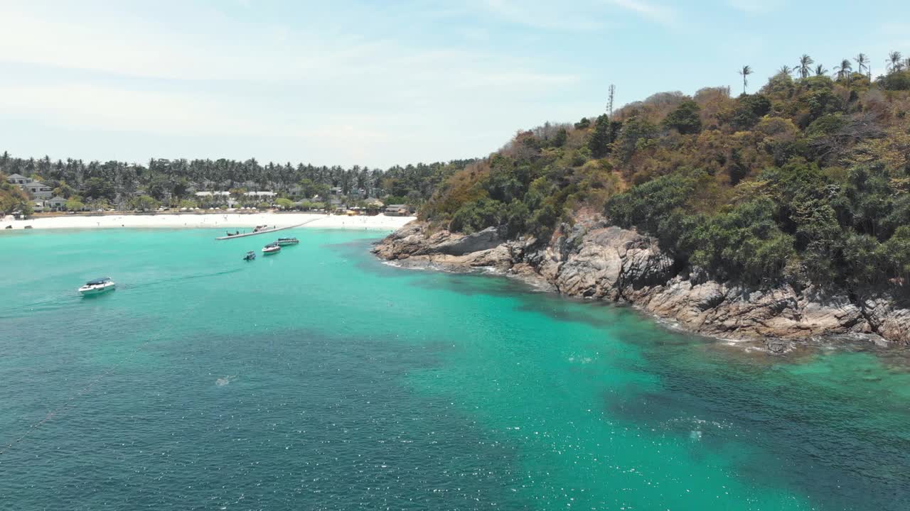 在泰国普吉岛海岸外，天堂般的绿宝石般清澈的海水中停泊着旅游船只的小海湾视频素材