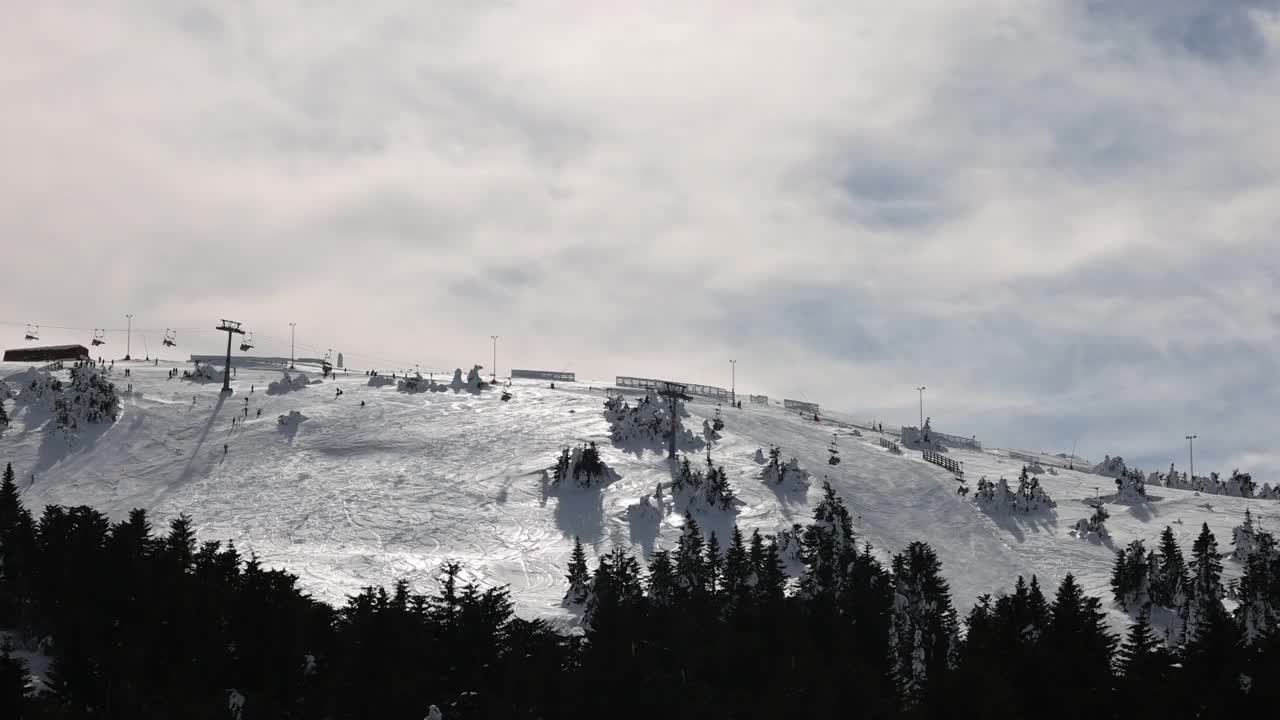 雪山滑雪坡道上的滑雪缆车和滑雪者视频素材