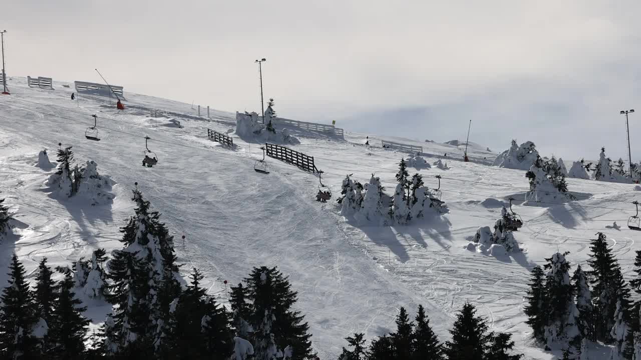 雪山滑雪坡道上的滑雪缆车和滑雪者视频素材