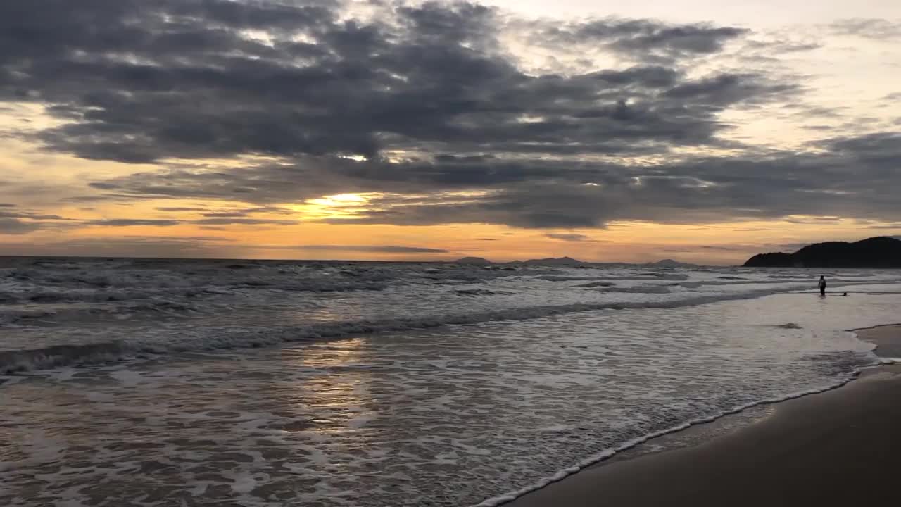 晚上海浪拍打着海滩。海面和海滩上生动的日落天空的反射。色彩斑斓的日出与云在海上，Chanthaburi省，亚洲泰国。视频素材