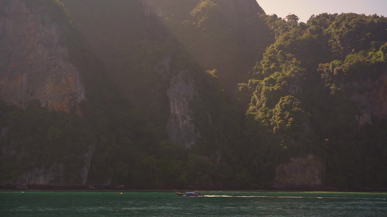 波光粼粼的海水和阳光照耀下对山的海滩视频素材