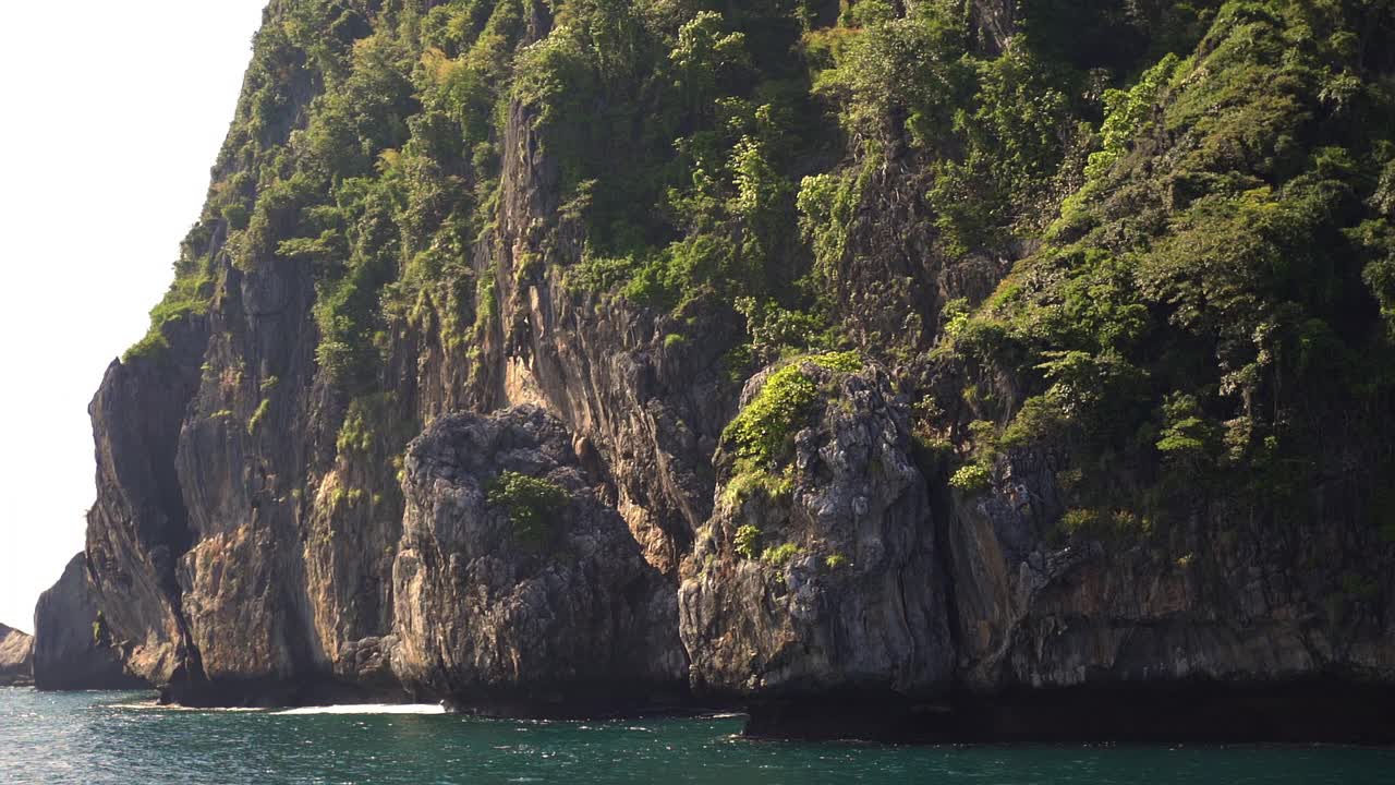 海边悬崖充满树和波光粼粼的海水Koh Phiphi海滩视频素材