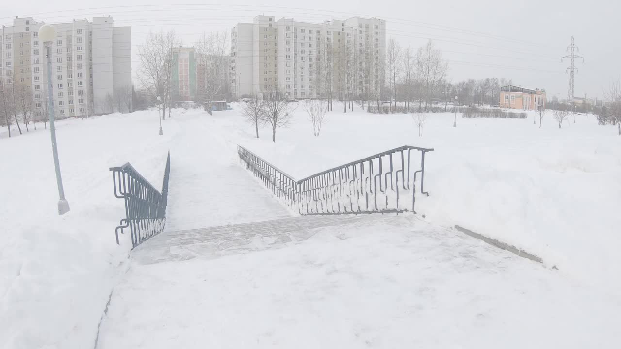 一场大雪过后，在莫斯科城市住宅区清理公园的小路视频素材