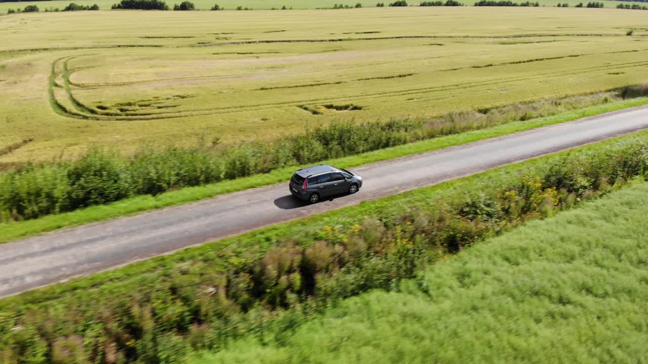 鸟瞰夏季行车道路农业区。乡间的柏油路，麦田。鸟瞰图公路旅行旅行旅行度假自然乡村乡村景观。视频素材