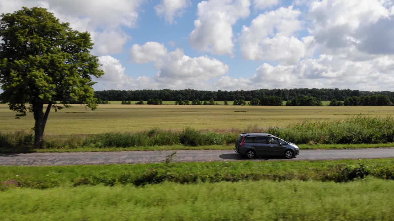 鸟瞰夏季行车道路农业区。乡间的柏油路，麦田。鸟瞰图公路旅行旅行旅行度假自然乡村乡村景观。视频素材