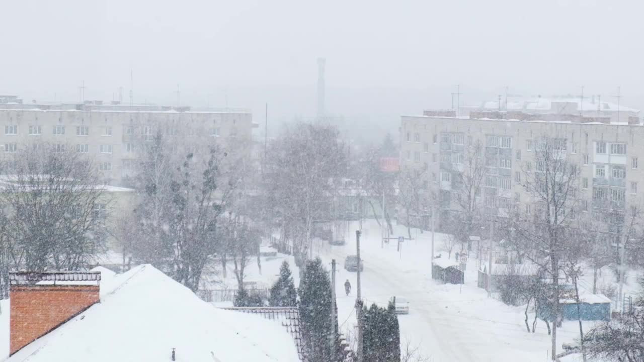 下雪的慢动作。白雪覆盖的城市，雪花飞舞的慢镜头。散焦。有选择性的重点。模糊的冬季背景寒冷的天气视频素材