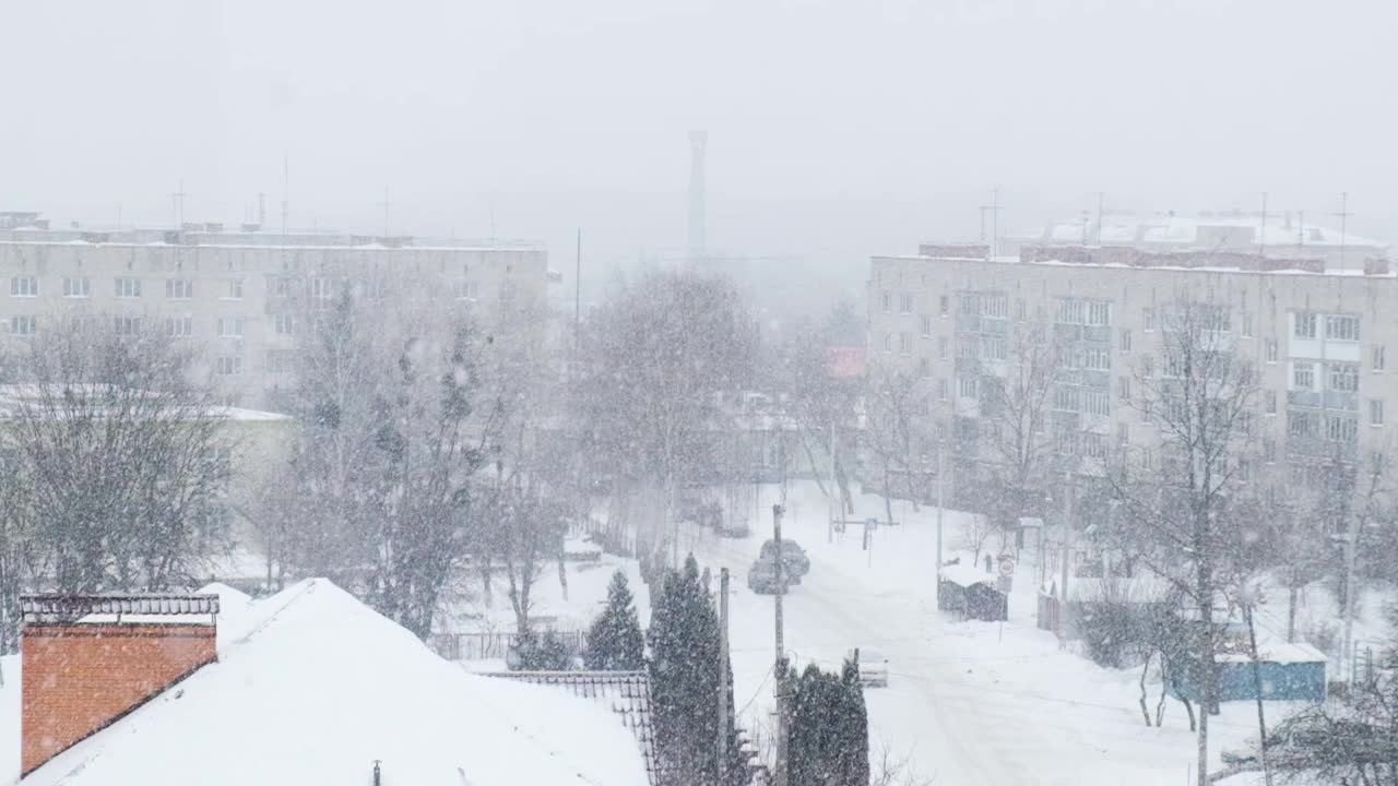 下雪的慢动作。白雪覆盖的城市，雪花飞舞的慢镜头。散焦。有选择性的重点。模糊的冬季背景寒冷的天气视频素材