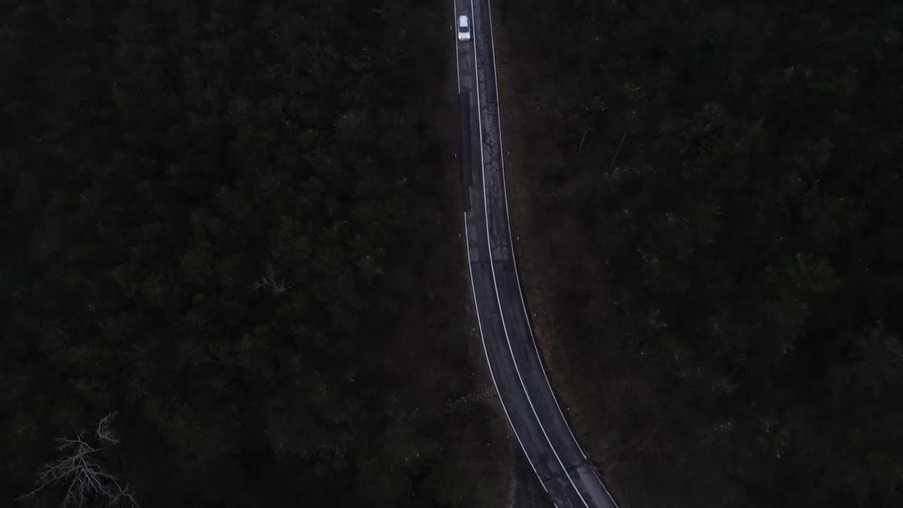 从无人机的角度跟踪拍摄的汽车在乡村道路上行驶的黄昏视频素材