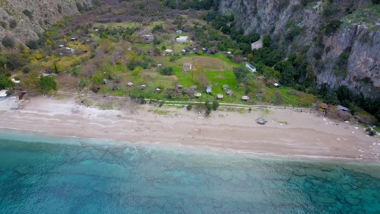 空中缩小隐蔽的海滩湾爱琴海蝴蝶谷Fethiye土耳其冬季(无人机- 4K)视频下载