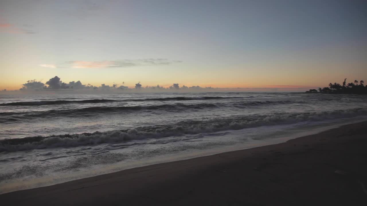 黎明时分，美国夏威夷考艾岛，波浪拍打着昏暗的海滩视频素材