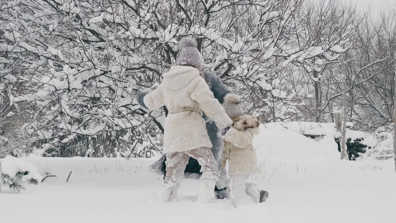 冬季家庭乐趣。幸福的家庭是享受雪和雪，在户外玩耍，在下雪的冬天一起在公园或森林里度过时光。慢动作视频素材