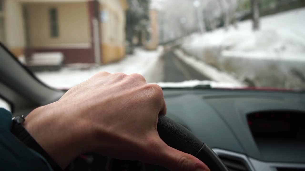 他在城里的一条冬天的路上开车。冬天注意路滑视频素材