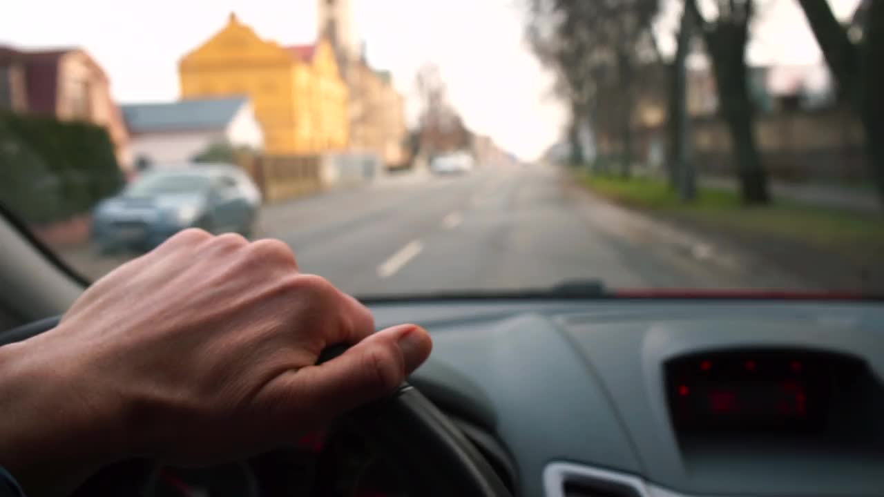 车在路上移动，从车里看。驾驶员用手驾驶车辆视频素材